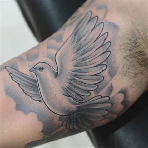 In this symbolic portrayal, the dove and butterfly dance together, representing a beautiful harmony between peace and transformation. . Dove tattoo mens